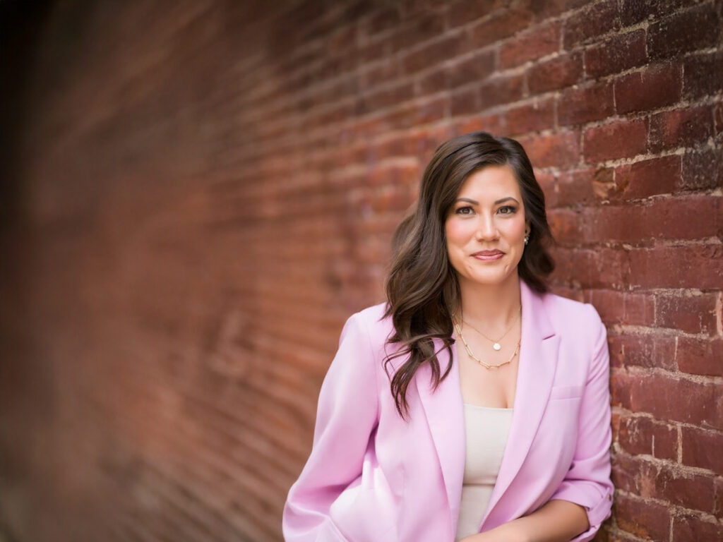 Dr. Ashley Ramp portrait against a brick wall.