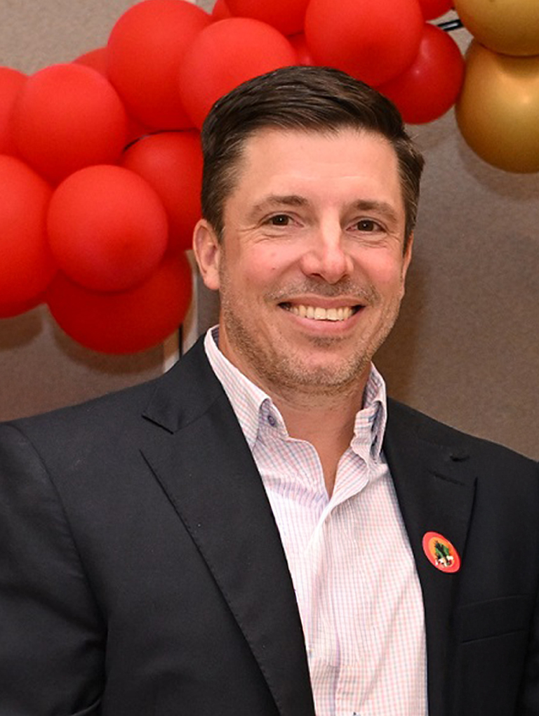 Dr. Dustin M. Riccio standing in front of a balloon decoration