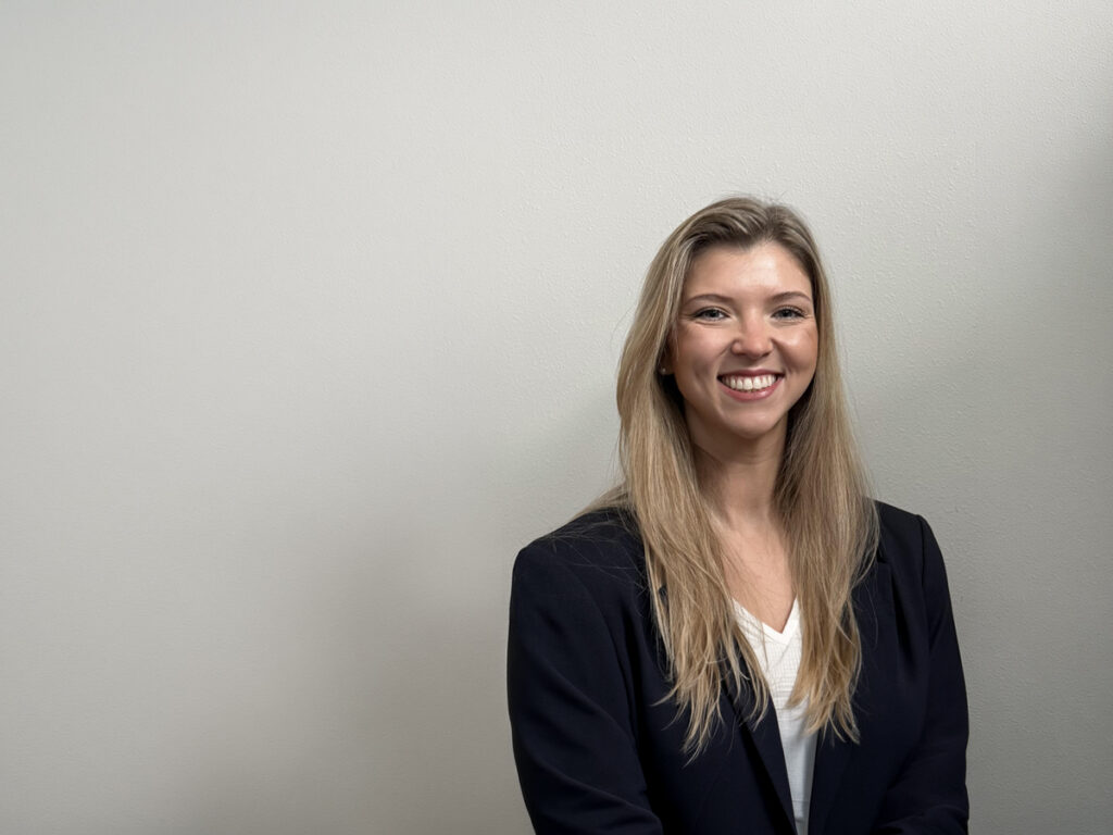 Courtney Wulffson standing in front of a white wall.