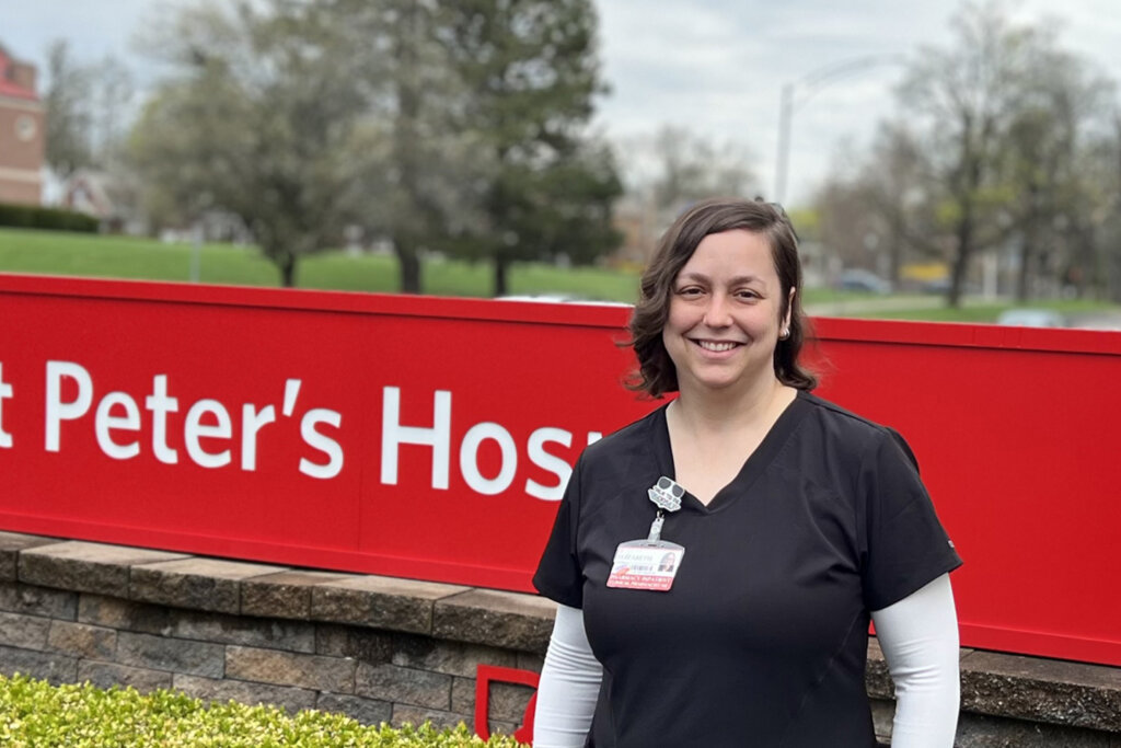 Dr. Elizabeth DeBell standing in front of St. Peter's Hospital sign.
