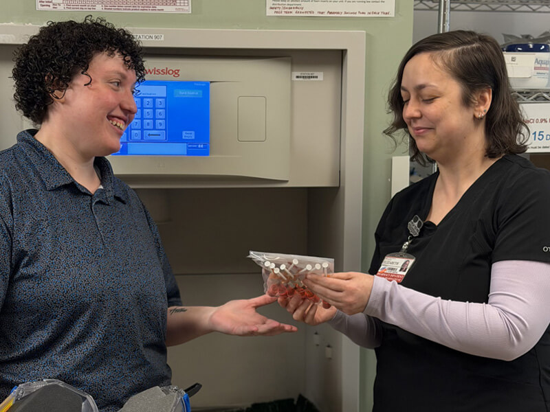 Dr. Elizabeth DeBell looking at medication with a colleague.