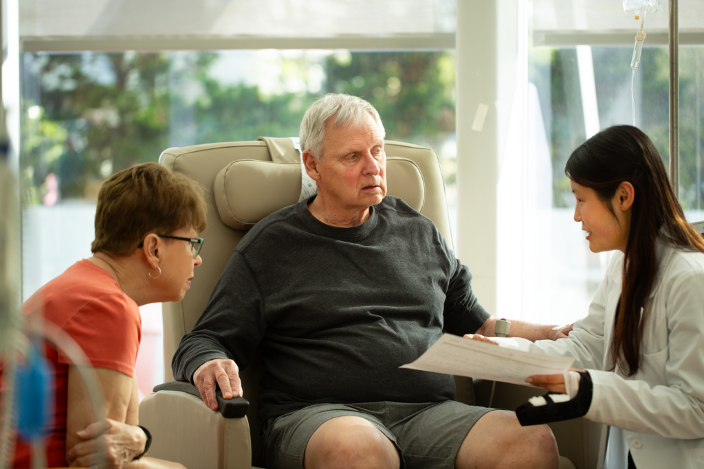 A pharmacist reviewing paperwork with a patient and their partner